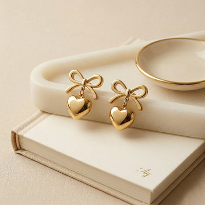 Designer Gold Plated Ribbon Bow Dangle Earrings with Polished Golden Heart Charms