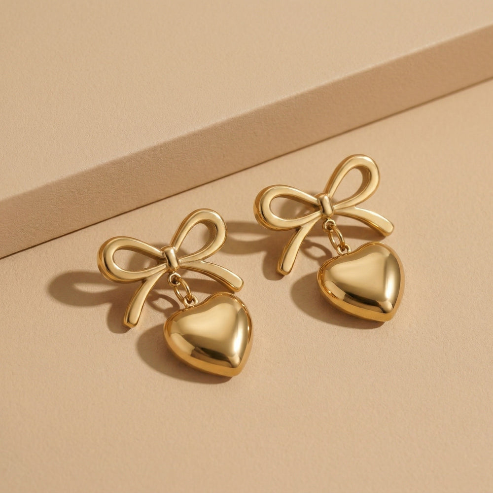 Designer Gold Plated Ribbon Bow Dangle Earrings with Polished Golden Heart Charms