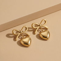 Designer Gold Plated Ribbon Bow Dangle Earrings with Polished Golden Heart Charms